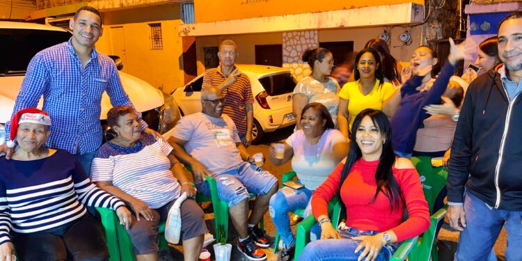 Miembros de ”Unidos al Barrio” reparten chocolate caliente entre sus vecinos por Navidad